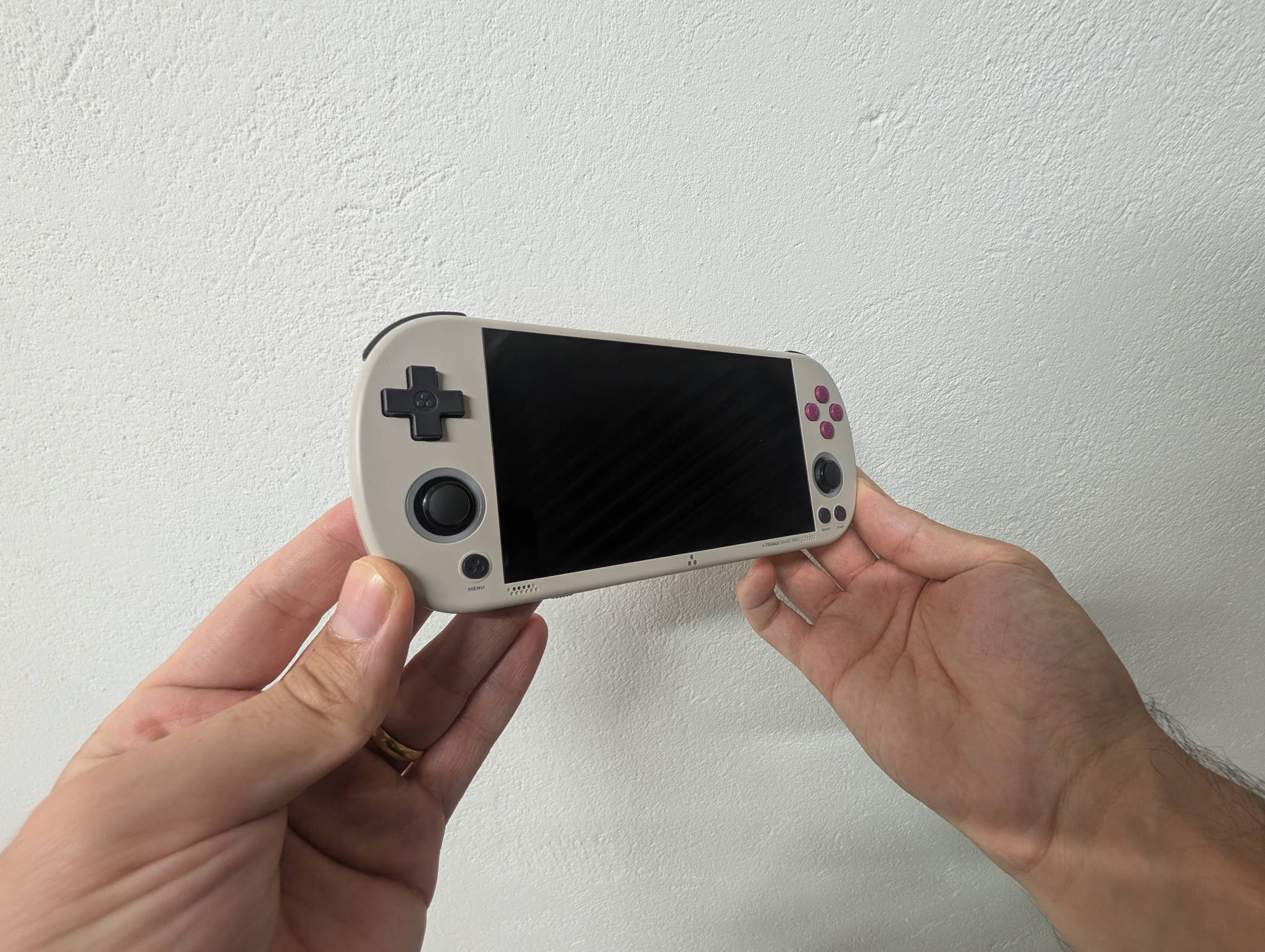TrimUI Smart Pro held in both hands running a game