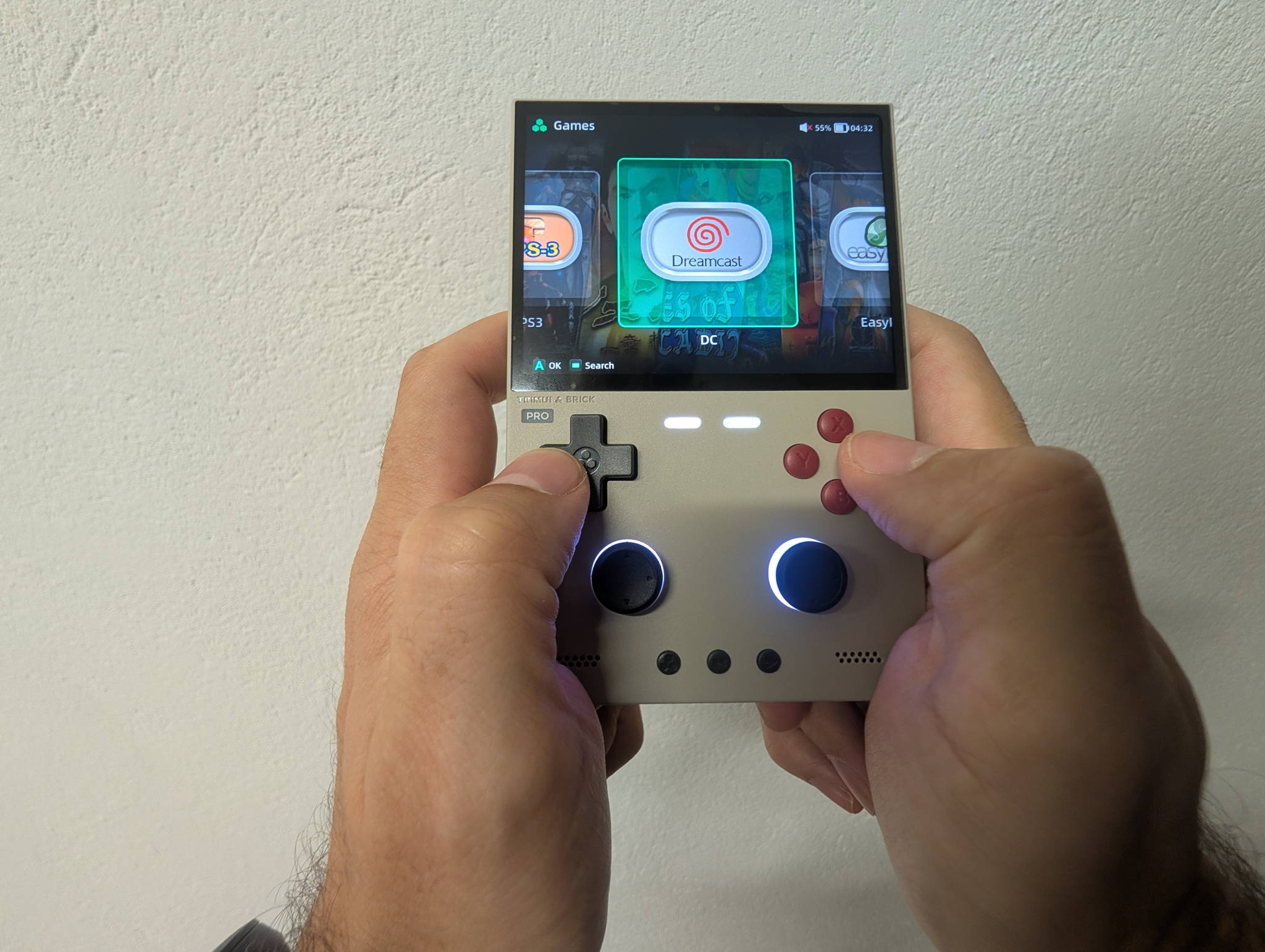 TrimUI Brick Pro held in both hands, mid-game