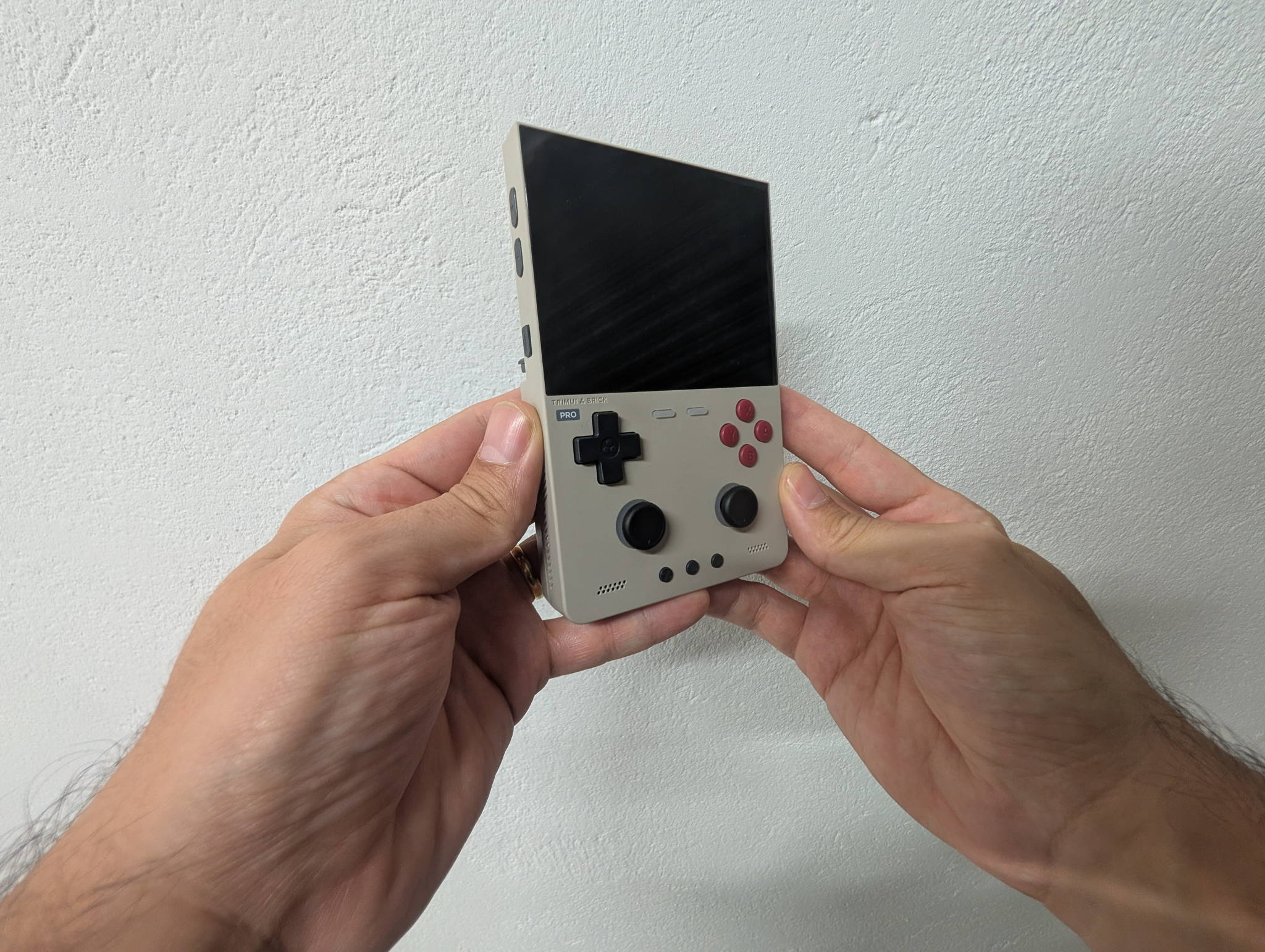 The TrimUI Brick Pro handheld showing its 3.95-inch 4:3 laminated display and dual Hall-effect sticks